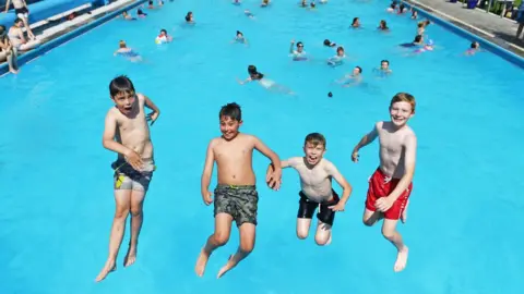 PA Media Children play in the water at Hathersage outdoor swimming pool