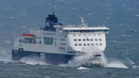 A DFDS roll-on/roll-off ferry arrives at the Port of Dover in Kent during rough seas.