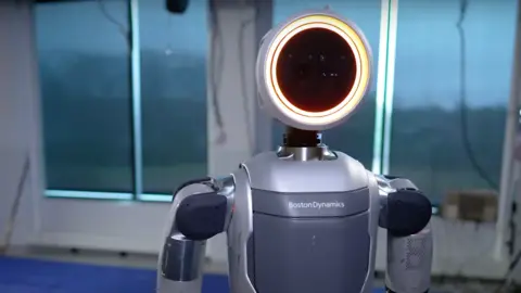 Boston Dynamics/YouTube The Atlas electric with a large round light for a head