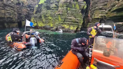 Caithness Diving Club Divers and an inflatable boat at sea cliffs