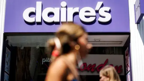 EPA Claire's store front in focus with some blurry people in the foreground