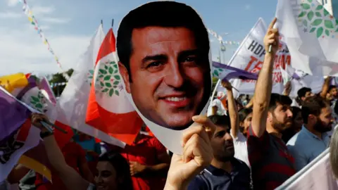 Reuters A supporter of Turkey's main pro-Kurdish Peoples' Democratic Party (HDP) holds a mask of their jailed former leader in 2018