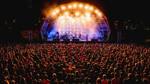 Ania Shrimpton A night shot of the crowd at the James concert illuminated by stage lights