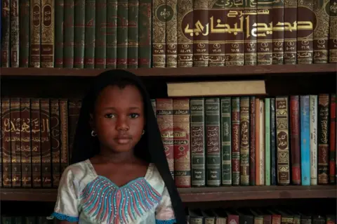 Reuters Kadiatou Diallo poses next to religious books during the first day of the Mulsim holy month of Ramadan, in Abidjan, Ivory Coast on 24 April.