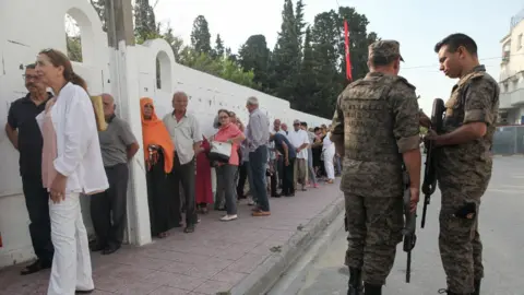 Getty Images Tunisian voters queue to cast their ballots at a polling station