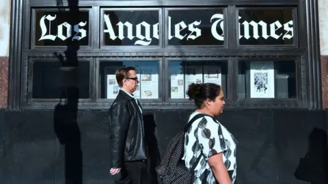 Getty Images People walking past LA Times building in LA