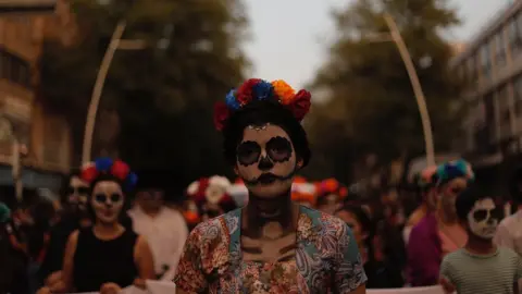 Getty Images A woman with full skull make-up and flower headband on