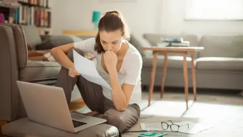 Getty Images woman looking at bills