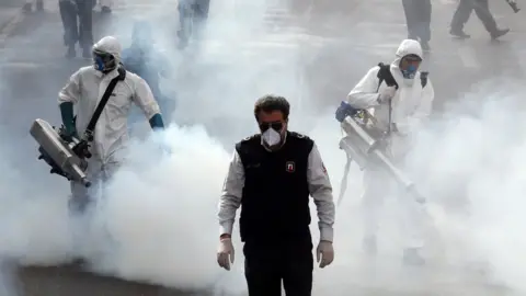 EPA Iranian firefighters disinfect streets in Tehran (13 March 2020)