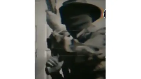 TikTok Screengrab from Tiktok showing a man with a large gun and using a Boogaloo hashtag