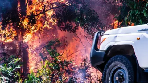 Getty Images Burning wildfire with vehicle