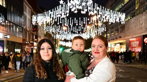 PA Media A Home-Start UK family attends the Oxford Street Christmas lights switch-on