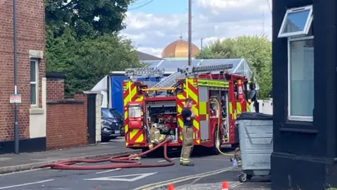 Firefighter and an engine next to a building