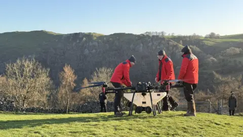 LIFE in the Ravines / Natural England A drone on the ground with three men in red jackets gathered around it. 