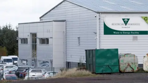 Reuters A large factory type building with a green and white sign on the side which reads Healthcare Environmental Group LTD Waste to Energy facility.