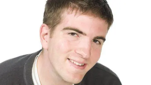 Image of Colin. He is smiling on a white background. He has short brown hair.