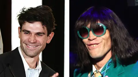 Getty Images A composite image shows KJ Apa on the left. He is on stage, applauding as he presents an award. On the right, Mr Fantasy, wearing large pale green sunglasses, smiles for the camera. Both men have similarly shaped chins and cheek dimples when they smile. Their noses also appear to be the same shape.