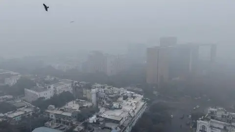 AFP via Getty Images Buildings engulfed in thick haze in Delhi's Connaught Place area on 18 December 2025 