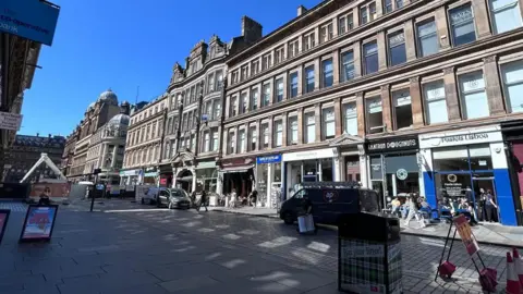 Gordon Street. The cordon is on the left and shops lines the street. 