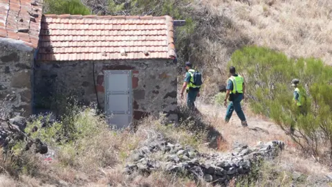 PA Media Two officers from the Guardia Civil search on the trail near the rural building