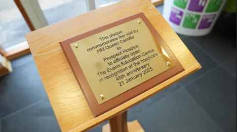 PA Media A plaque resting on a podium with the word: "this plaque commemorates the visit by HM Queen Camilla to Prospect Hospice to officially open The Evans Education Centre in recognition of the hospice's 45th anniversary, 21 January 2025"