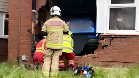 Firefighters at the broken wall