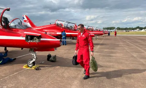A Red Arrows pilot prepares to get into his plane at the Royal International Air Tattoo