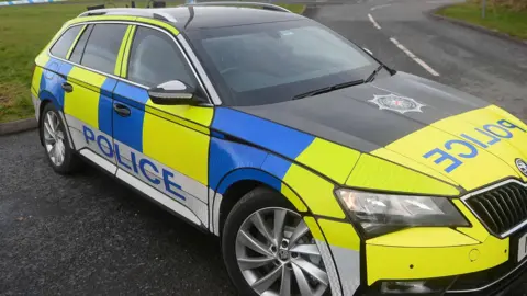 SHUTTERSTOCK A PSNI car. It is yellow and blue