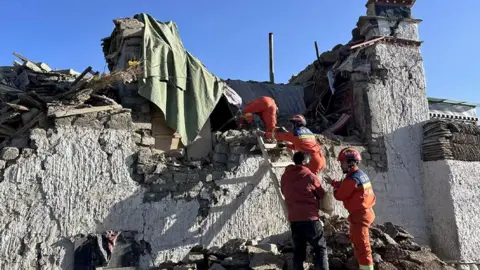 Rescuers work on a collapsed house in the earthquake-affected area in Changsuo Township of Dingri