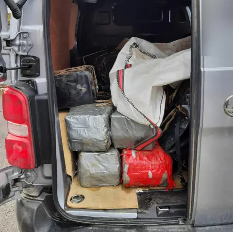 NCA Parcels stacked up in the back of a grey van with door open