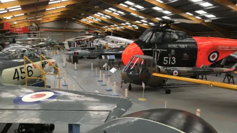Hangar 1 at Newark Air Museum, showing various aircraft, including helicopters, separated by a central walkway