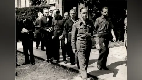 Trent Park Museum Trust A black and white image of a group German prisoners of war in World War Two. They are wearing uniform.
