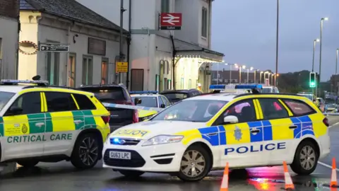 Eddie Mitchell Police cars and paramedic vehicles outside Seaford railway station.