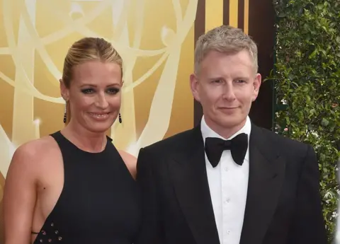 Getty Images Cat Deeley and Patrick Kielty pose in front of yellow background.