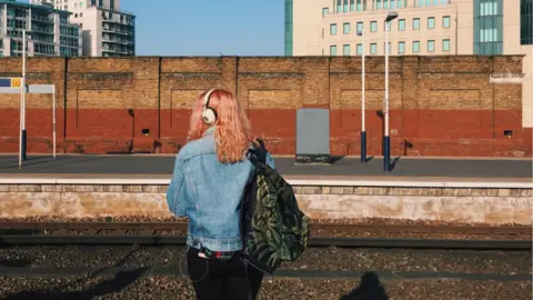 Getty Images A woman waits at a train platform