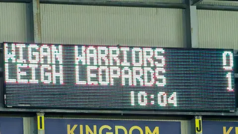 A scoreboard showing Wigan Warriors 0-1 Leigh Leopards