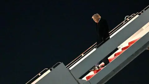 Man walks down plane stair case