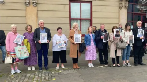 Relatives of patients at Muckamore Abbey Hospital hold photos of their loved ones