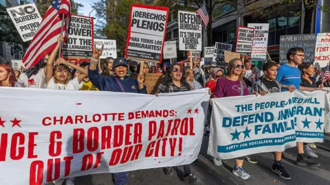 Protesters in Charlotte, North Carolina march and carry signs protesting US Border Patrol's immigration crackdown in their city