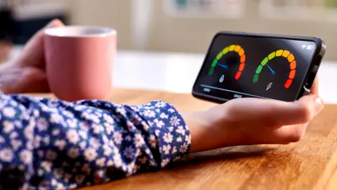 Getty Images A woman reads a smart meter on her phone