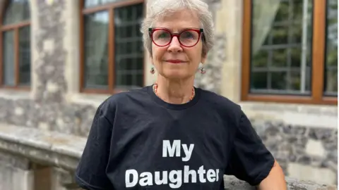 Vicky Unwin stood in front of a building wear a t-shirt that says "my daughter".
