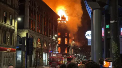 Union Corner on fire on a city street at night 