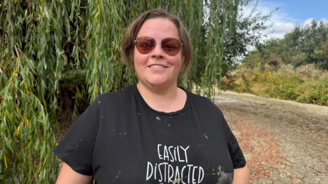 A woman in a black top with sunglasses.