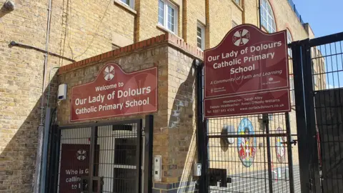 Front of school gates with sign for Our Lady of Dolours