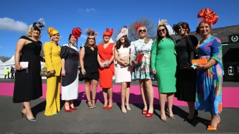 PA Media Women pose for photos on Ladies Day at Aintree