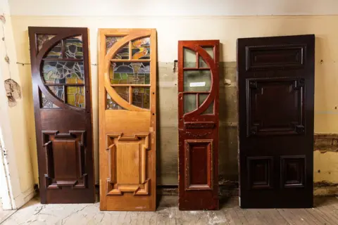 Annaleen Lindsay A selection of old wooden doors that are in the process of being revamped - two have colourful stained glass pannels