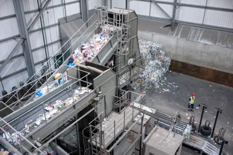 Phil Coomes / BBC Conveyor belts carrying piles of recycling