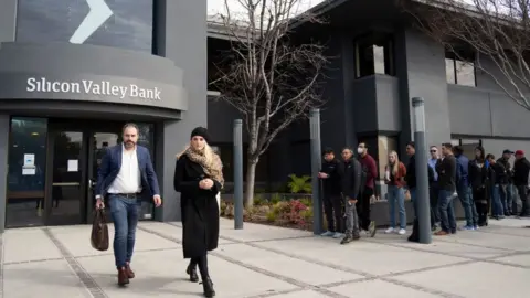 Getty Images People queue up outside the headquarters of Silicon Valley Bank to withdraw their funds on March 13, 2023 in Santa Clara, California.