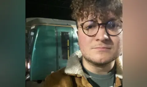 Marcus Patterson Marcus Patterson is standing in front of a green train. He is wearing glasses and the photo was taken in the dark. He has curly brown hair.