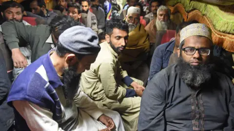 The passengers of the AFP train sit on a bus after being released by armed militants who ambushed the train in the remote mountain area of ​​the province of southwest Baluchistan